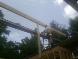 Carpenter setting a ridge beam over a new addition frame — Ice Dam Removal by Roofing Brothers in Jamestown