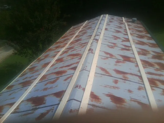 Rusted metal roof panels with new wood purlins before replacement — Storm Damage Roof Repair in Jamestown by Roofing Brothers